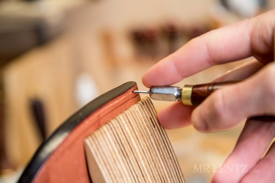 using diamond awl to punch stitching holes in sheath