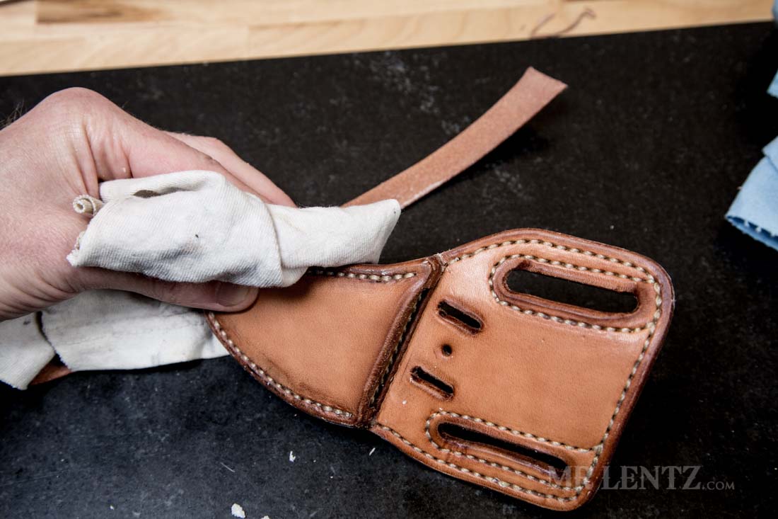 hand buffing the edge of a polished knife sheath