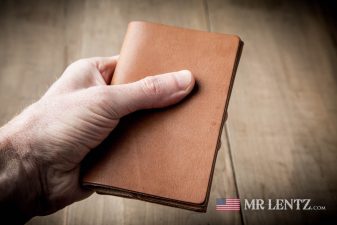 holding a brown leather card wallet